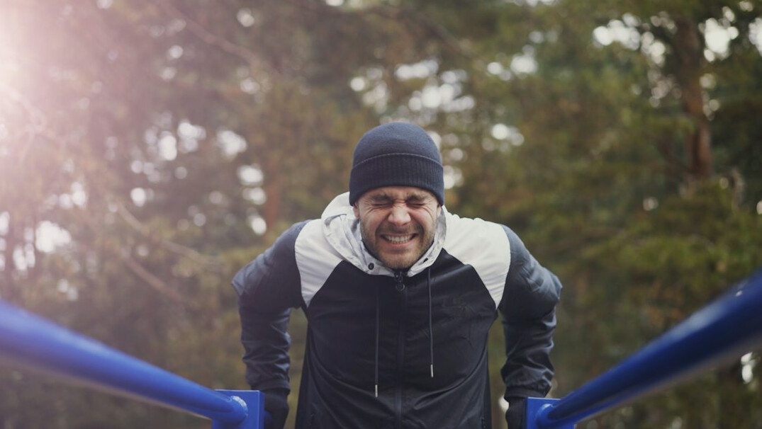 Smiling man in a blue sweater outdoors
